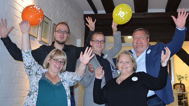 eine Gruppe von Menschen, die Ballons in der Luft halten und sich freuen